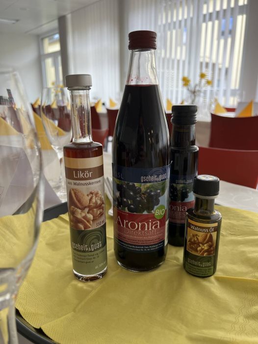 Am Bild sind drei Flaschen mit Walnusslikör, Aroniasaft und Walnussöl